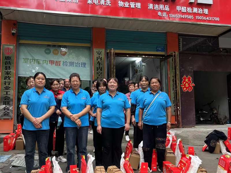 鹿邑美家保洁员工团队在鹿邑美家家政门店前合影,身穿统一蓝色工服,展现鹿邑家政服务团队风貌。