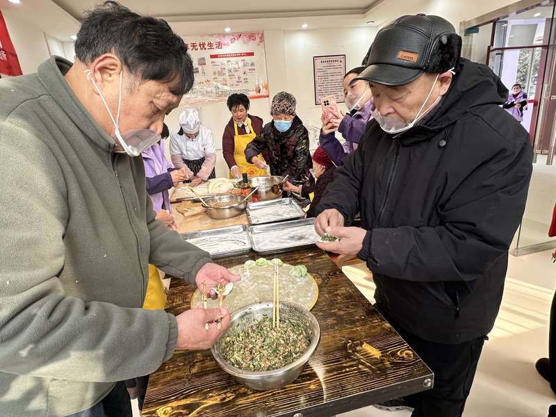 鹿邑社区老人在日间照料中心参与包饺子,体现助餐+社交相结合的社区养老服务。